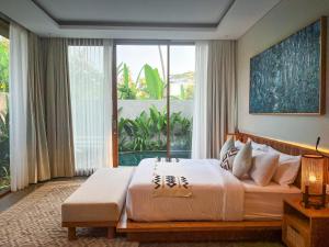 a bedroom with a large bed and a large window at Villa Suarga Des Anicca in Ubud +37 photos