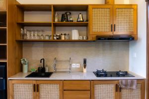 a kitchen with wooden cabinets and a counter top at Villa Suarga Des Anicca in Ubud