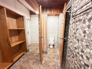 a bathroom with a toilet and a walk in shower at Bunaken Guesthouse The Queen's in Bunaken +17 photos