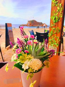 a vase of flowers sitting on a table near the beach at 2 bedroom large modern apartment in Blanes Old Town 50m from the beach! in Blanes