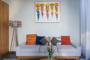 a living room with a couch and a picture on the wall at Villa Suarga Des Anicca in Ubud
