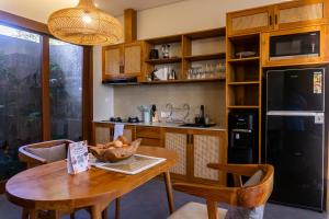 a kitchen with a table with a bowl of fruit on it at Villa Suarga Des Anicca in Ubud