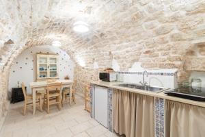 une cuisine et une salle à manger avec un mur en pierre dans l'établissement Dimora Marter, city center, à Conversano
