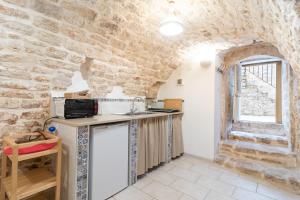 une cuisine avec un comptoir et un mur en pierre dans l'établissement Dimora Marter, city center, à Conversano 19 autres photos