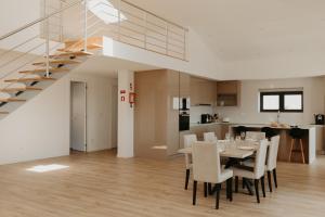 a dining room with a table and chairs and a staircase at RealGoios in Esposende
