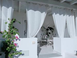 a room with white curtains and tables and chairs at Sikelia elegant suite in Lipari
