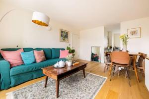 a living room with a green couch and a table at Stunning 2 Bed Ensuite Apart in London