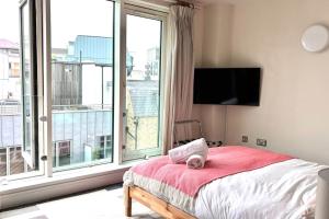 a bedroom with a bed and a large window at Stunning 2 Bed Ensuite Apart in London