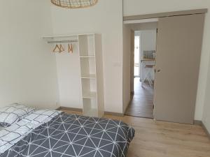 a bedroom with a bed and a hallway with a desk at Logement indépendant in Guécélard