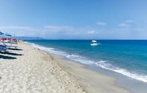a boat in the ocean next to a beach at 1 Bedroom Amazing Apartment In Staletti in Stalettì +10 photos