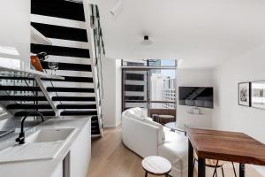 a kitchen and living room with a couch and a table at KozyGuru Sydney CBD Harbor View Loft with Parking in Sydney