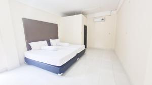 a bedroom with a bed in a white room at Homestay Tasya in Labuan Bajo +10 photos