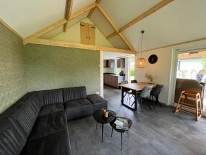 Campingpark de Linie في Opheusden: غرفة معيشة مع أريكة وطاولة