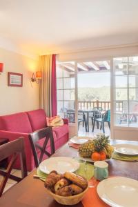 ein Wohnzimmer mit einem Tisch mit Essen drauf in der Unterkunft Résidence Pierre & Vacances Le Domaine de Gascogne in Biscarrosse