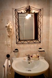 a bathroom with a sink and a mirror at Hotel Boccascena in Genoa