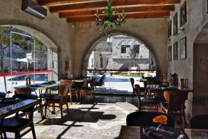 een restaurant met tafels en stoelen en een kroonluchter bij Göreme Cave Suites in Goreme