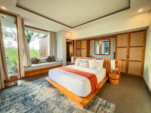 a bedroom with a large bed and a large window at Villa Suarga Des Anicca in Ubud