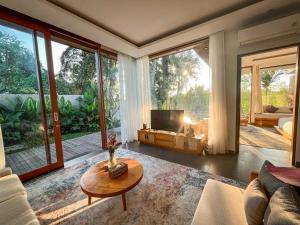 a living room with a couch and a table at Villa Suarga Des Anicca in Ubud