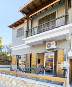 a house with a balcony with chairs and a table at La Magenta Apartments in Pyla