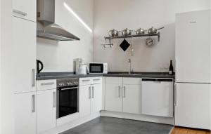 a kitchen with white cabinets and a white refrigerator at Three-Bedroom Holiday Home In Askeby in Askeby