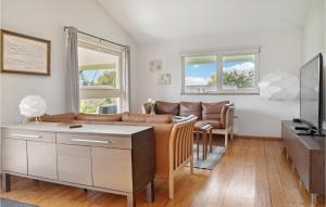 a living room with a couch and a tv at Three-Bedroom Holiday Home In Askeby in Askeby