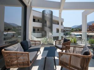 a balcony with chairs and a couch and a table at Mare Village Hotel in Georgioupolis
