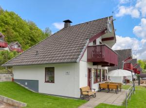 une maison blanche avec un balcon et une table dans l'établissement Haus Sonnenschein, Seepark Kirchheim, à Kirchheim