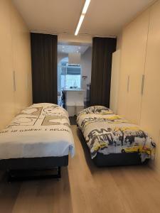 two twin beds in a room with a desk at Brugmann Loft Apartment in Brussels