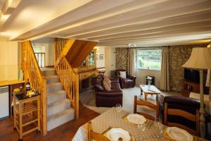 a living room with a staircase and a living room at Ash Cottage - Escape to Pembrokeshire Cottage with Pool & Sauna in HAW
