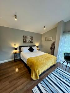 a bedroom with a bed with a yellow blanket at River Bann Retreat in Portglenone