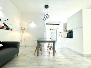 eine Küche und ein Esszimmer mit einem Tisch und einer Couch in der Unterkunft La Corte di Nonna Gina in Tortolì