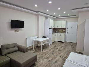 a living room with a couch and a table and a kitchen at Gardi Apart Hotel in Batumi