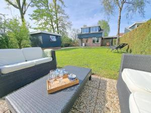 a patio with a couch and a tray of wine glasses at Vakantiehuis Heinkenszand VP002 met privésauna in Heinkensand