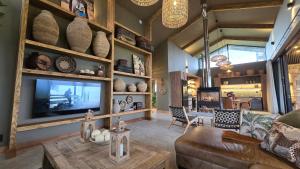 a living room with a couch and a tv at Buff & Fellow Eco Cabins in George
