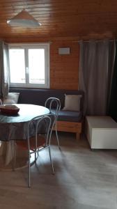 a room with a table and a couch and a bed at Chalet familial entre les pins in Agde