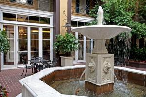 a fountain with a statue in the middle of a courtyard at Hotel Mazarin in New Orleans