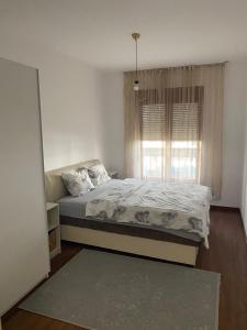 a bedroom with a bed and a window at Apartman City Kvart Podgorica lux in Podgorica