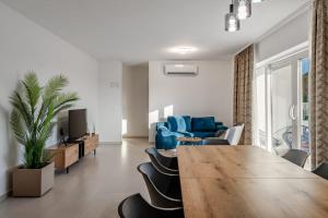 a living room with a table and a blue couch at Luxury Villa Vrsi with Private pool in Vrsi