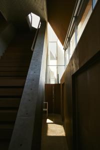 een trappenhuis in een gebouw met een stoel in het zonlicht bij A&A Okayama in Okayama +27 foto's