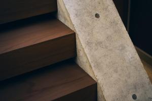 a concrete staircase in a room with wooden floors at A&A Okayama in Okayama