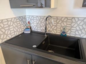 a kitchen sink with a black counter top at The Viewpoint in Deal +54 photos