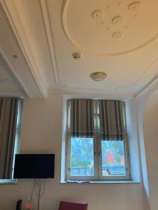 a living room with a window and a tv at Les Roques Apartments in historical Monastery in Durbuy