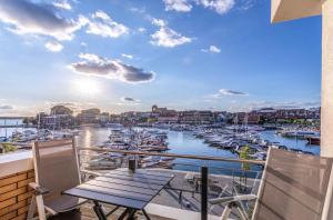 einen Balkon mit Blick auf einen Yachthafen mit Booten in der Unterkunft Hafenperle - Apartment mit Balkon & Wellnessbereich in der Hafenresidenz in Waren (Müritz)