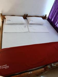 ゴカルナにあるShreekrishna iWOODS HOMESTAYの枕が2つ置かれたベッド