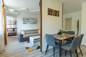 a dining room with a table and chairs and a couch at Sweet Home 2 in Sandanski