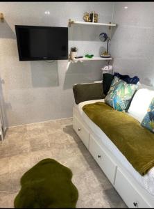 Un dormitorio con una cama con un televisor de pantalla plana en la pared. en Oakwood Cabin Retreat in Bexleyheath, en Kent 13 fotos más