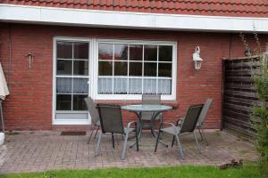 a table and chairs in front of a brick house at Seerobbe in Norddeich