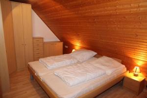 a bed in a room with a wooden wall at Seerobbe in Norddeich