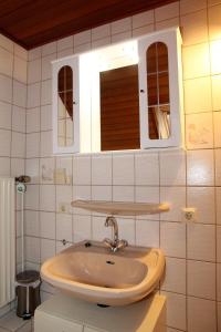 a bathroom with a sink and a mirror at Seerobbe in Norddeich +13 photos