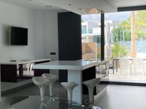 a kitchen with a counter with stools and a table at Villa Lux Mar in Cala Llena